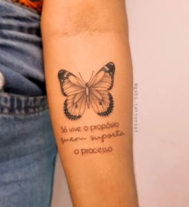 Tatuagem de borboleta no antebraço com frase